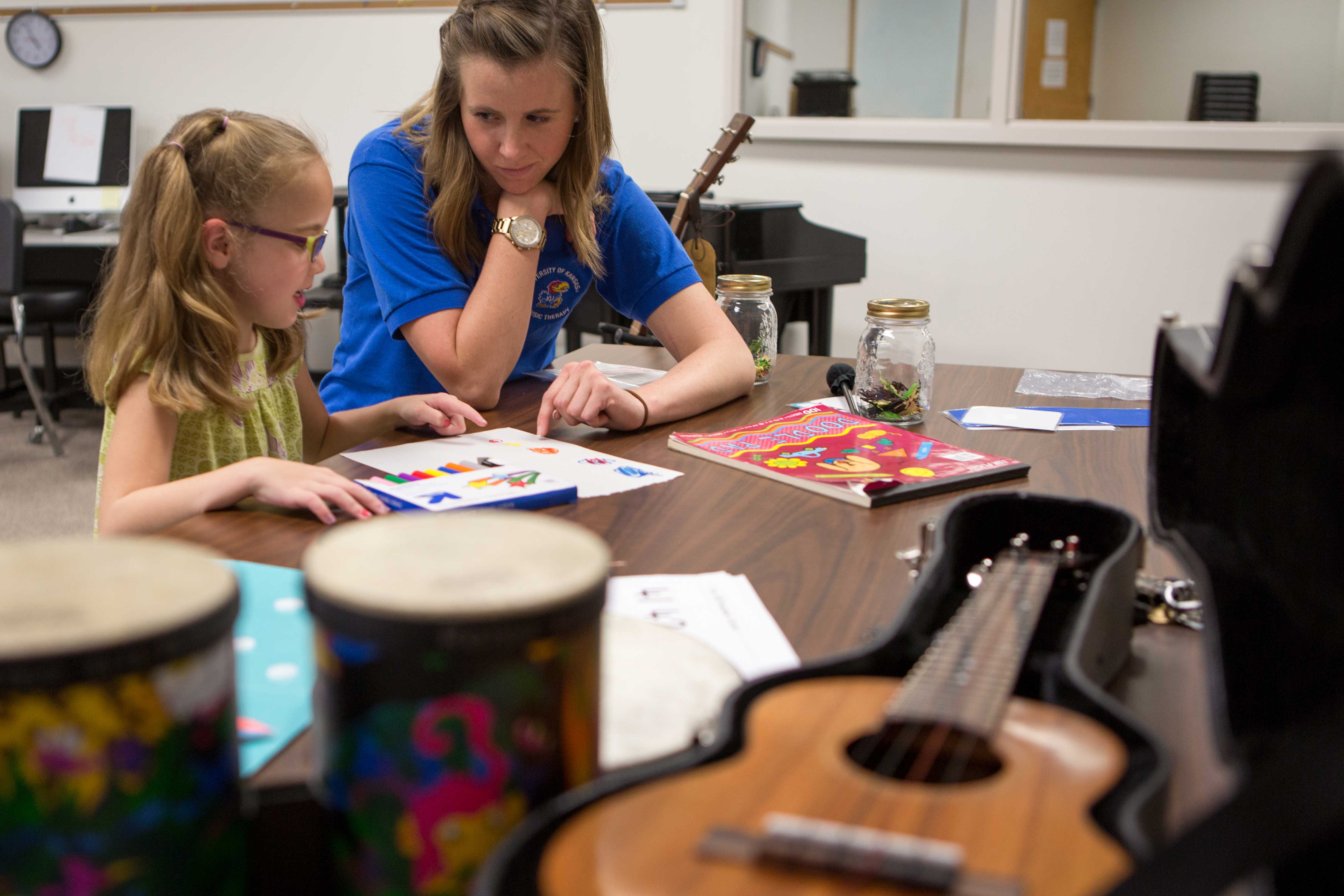 Teacher showing student colors in a coloring book